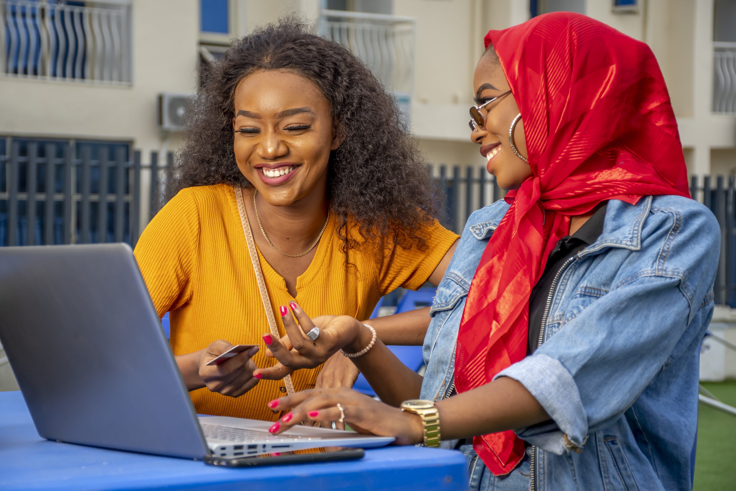 closeup shot two cheerful young african ladies laptop scaled 1